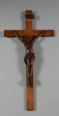 crucifix en bois représentant Jésus sur la croix, accroché à un mur blanc
