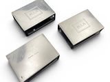 three silver metal business cards on a white surface with a white background