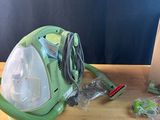 a green vacuum that is sitting on a wooden table