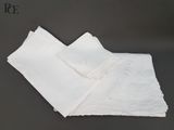 deux serviettes blanches ornées de dentelle posées sur une table