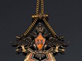 a close up of a gold and black pendant with two birds on it