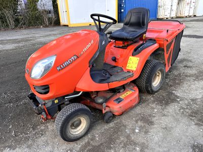 une tondeuse à gazon rouge garée devant un immeuble