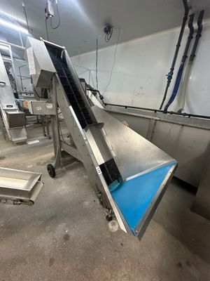 une image représentant un tapis roulant dans une usine, avec un autre tapis roulant au milieu