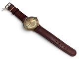 brown leather watch strap with a gold plated watch face on a white background