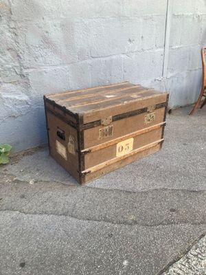 une petite boîte en bois posée sur le trottoir, à côté d'une chaise