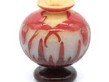 un vase rouge et blanc posé sur un socle en bois