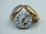 a gold and silver pocket watch with roman numerals on it