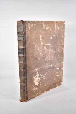 un vieux livre posé sur une table blanche à côté d'un mur blanc