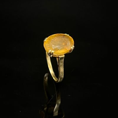 Gros plan sur une bague contenant une pierre jaune
