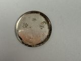 a small coin that is sitting on a white surface