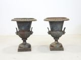 two metal vases sitting on top of each other