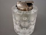 a small glass jar with a metal lid on a table