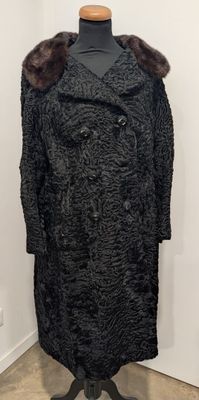 manteau noir avec col et poignets en fourrure, présenté sur un mannequin