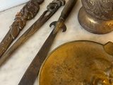 a gold plate with a knife, spoon, and other items on it
