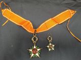 médaille et paire de boucles d'oreilles avec un ruban orange sur fond noir