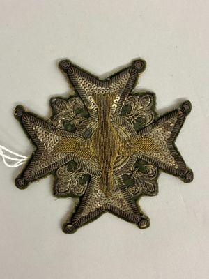 une image représentant une broche en forme d'étoile posée sur une surface blanche