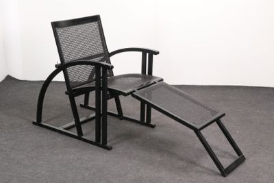 une chaise noire avec un repose-pieds posé au sol