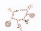 an image of a silver bracelet with charms and a coin