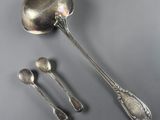 two spoons and a spoon rest on a gray surface