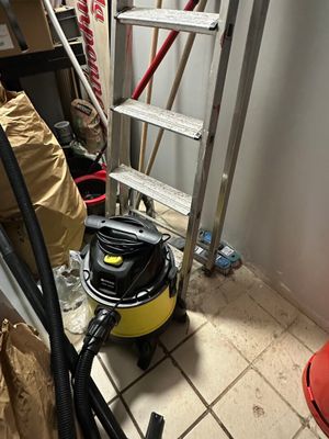 un aspirateur posé par terre à côté d'une échelle