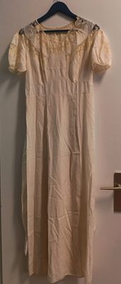 une robe de couleur crème suspendue à un cintre dans une pièce