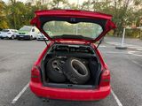 a red car with two tires in the back of it