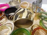 many different colored bangles and bracelets on a table