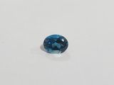 an oval blue topaze gems on a white surface