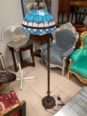 several chairs and a table with a lamp on it in a room
