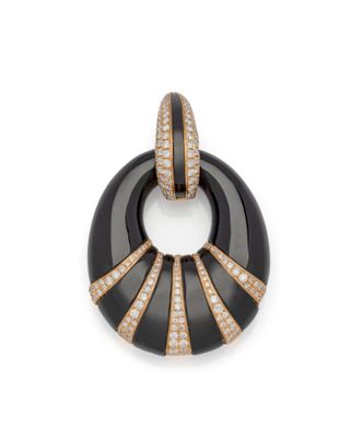 une photo d'un pendentif noir et or serti de diamants