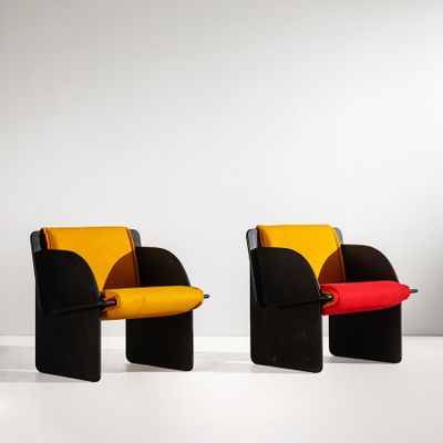 Trois chaises aux coussins de couleurs différentes sont disposées dans une pièce blanche