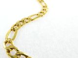 a close up of a gold chain bracelet on a white surface