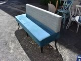 a blue bench sitting in the middle of a parking lot