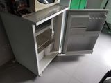 a small refrigerator with a microwave on top of it