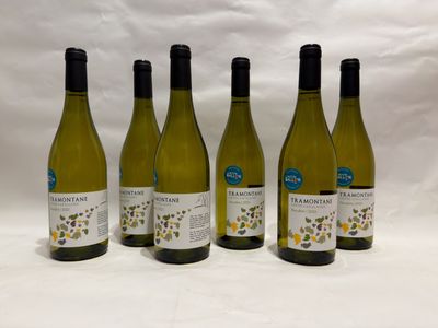 four bottles of wine are lined up on a white surface