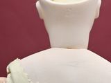 a white vase with a candle in it sitting on a table