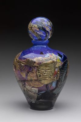 une photo d'un vase en verre bleu orné de feuilles d'or