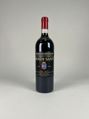 the bottle of red wine is sitting on a white surface
