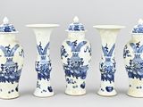 quatre vases bleus et blancs sont alignés sur un fond gris