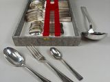 une boîte contenant des couverts et des cuillères, posée sur une table