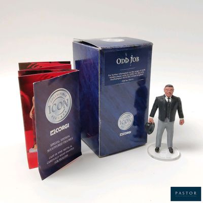 a figurine of a man in a suit and tie next to a box