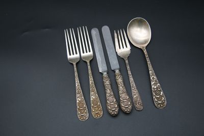quatre fourchettes et cuillères sont posées les unes à côté des autres sur une table