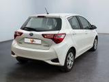 the rear end of a white toyota yaris parked in a room