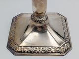a silver candle holder that is on a table