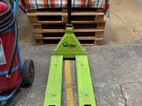 un chariot élévateur vert posé à côté d'un extincteur rouge
