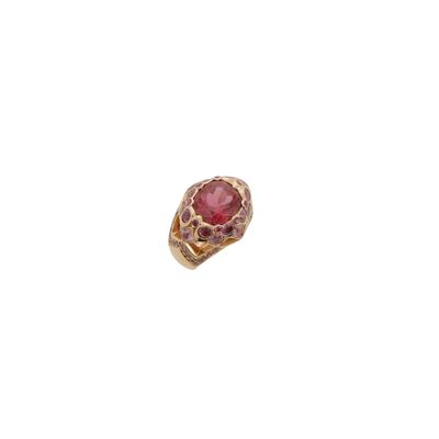 gros plan d'une bague en or avec une pierre rose