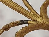 a close up of a gold sculpture with a bird on it