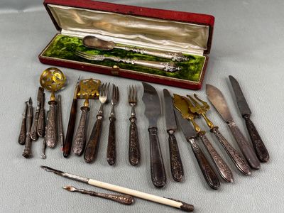 many different types of knives and spoons in a case