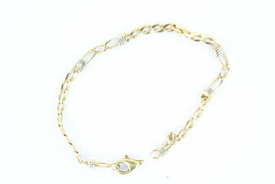 gros plan d'un bracelet en chaîne en or sur fond blanc