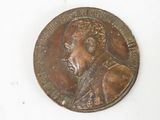 a bronze medal on a white surface with a picture of a man